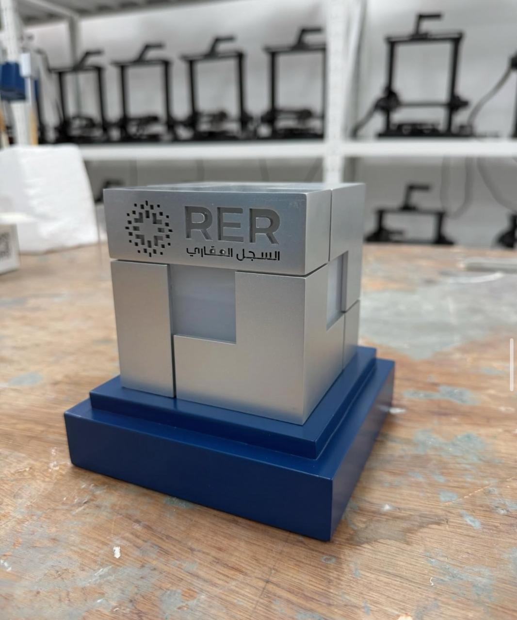 Grey geometric RER branded model on a blue stepped base